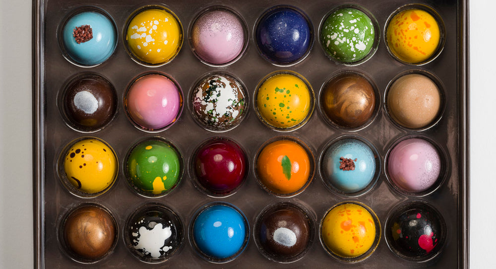 Close up, overhead view of the assorted colorful bonbons in 24 pieces signature bonbon box - white background