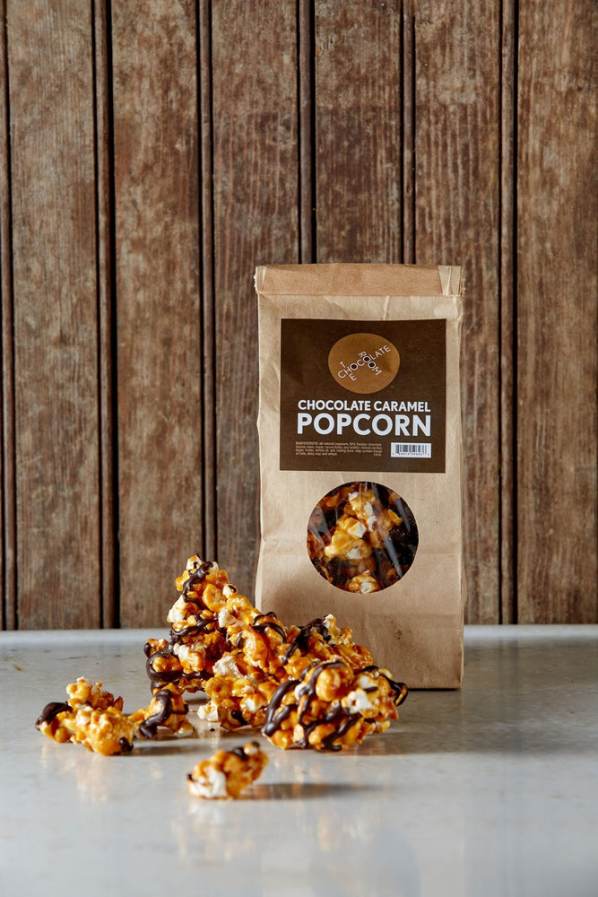 Branded package of chocolate caramel popcorn. Packaging has a round window. Mouthwatering chocolate caramel popcorn in front