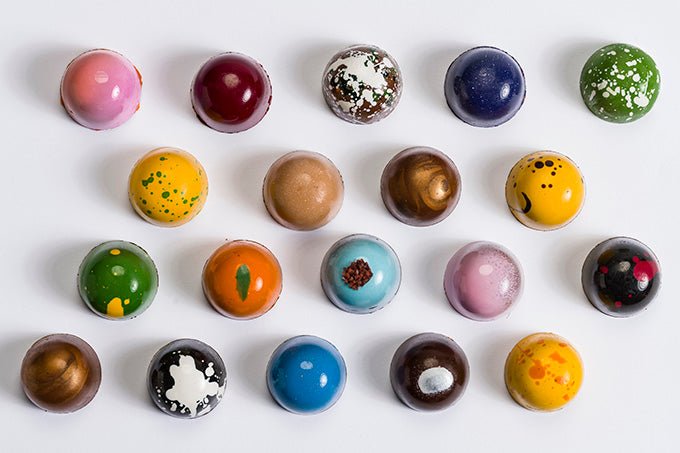 
                  
                    Overhead shot of 19 assorted colorful hand painted bonbons
                  
                