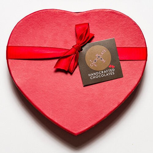 Top view of a branded red heart shaped branded bonbon box with a red bow